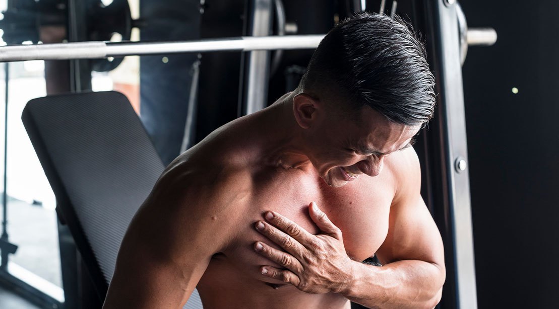 Fit muscular man suffering from a pec tear due to bad form with bench pressing