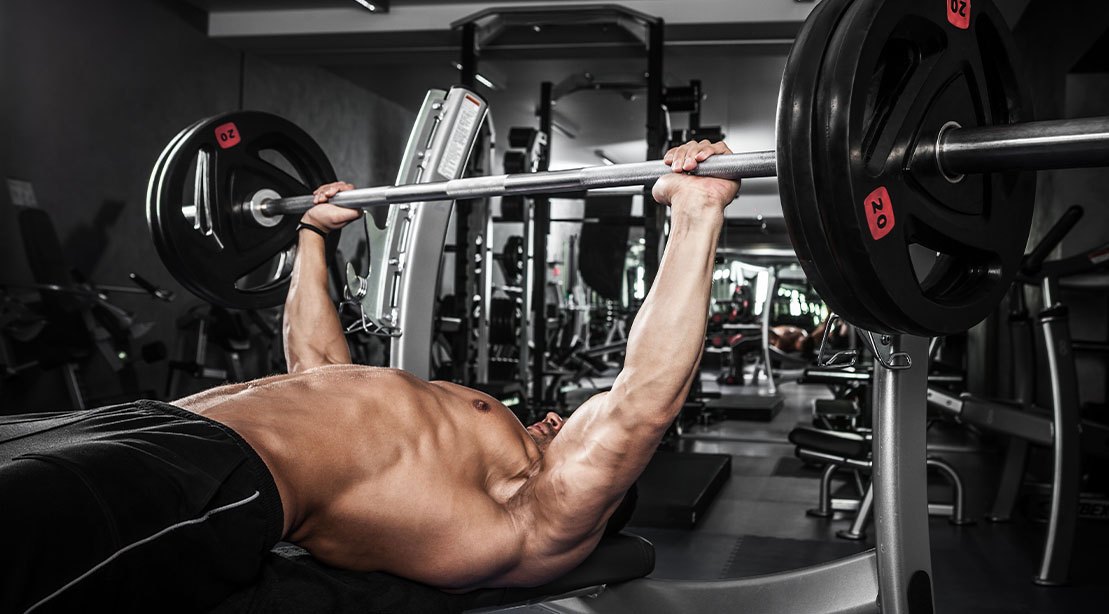 Muscular bodybuilder performing a bench press with aligned hands wrists and elbows