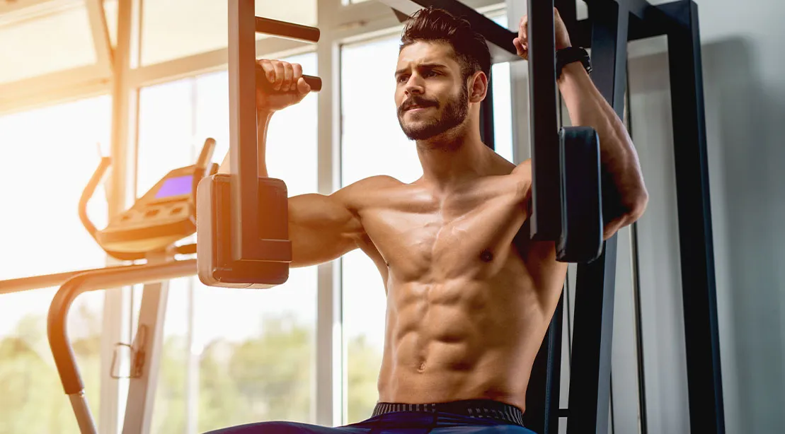 Muscular and physically fit man using the pec deck for his chest workout
